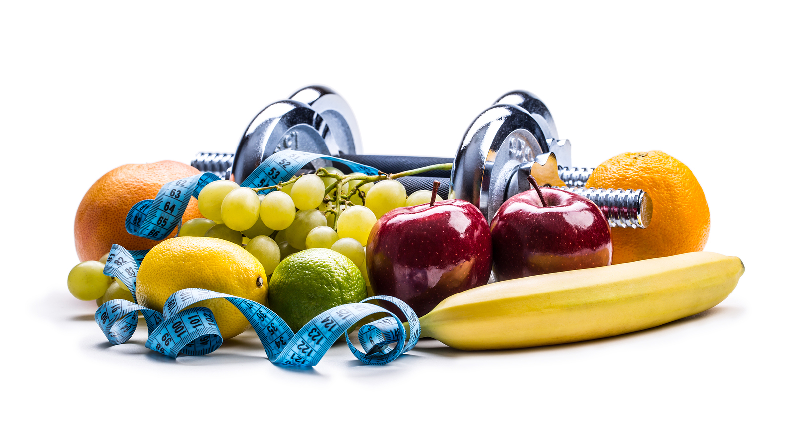 Chrome dumbbells surrounded with healthy fruits measuring tape on a white background with shadows. Healthy lifestyle diet and exercise.